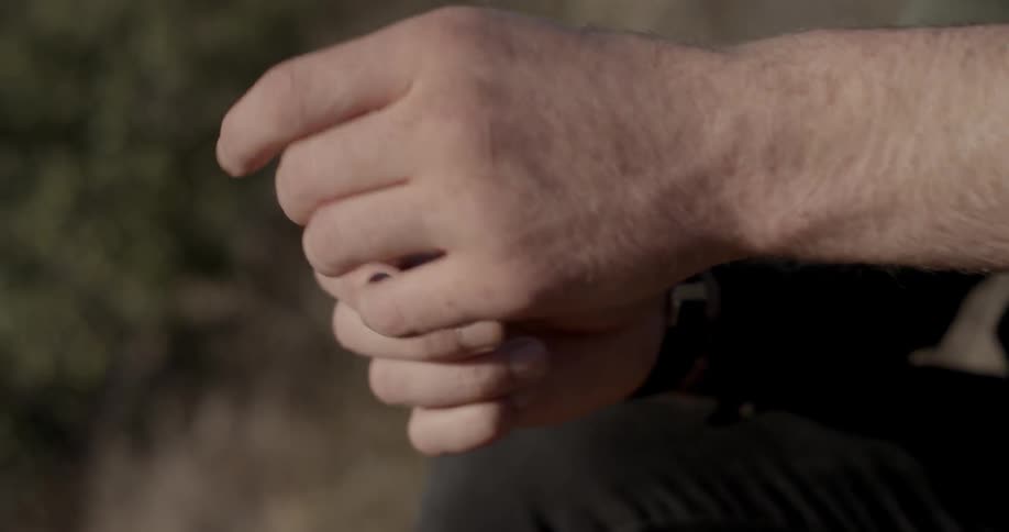 A person fiddles with a stick