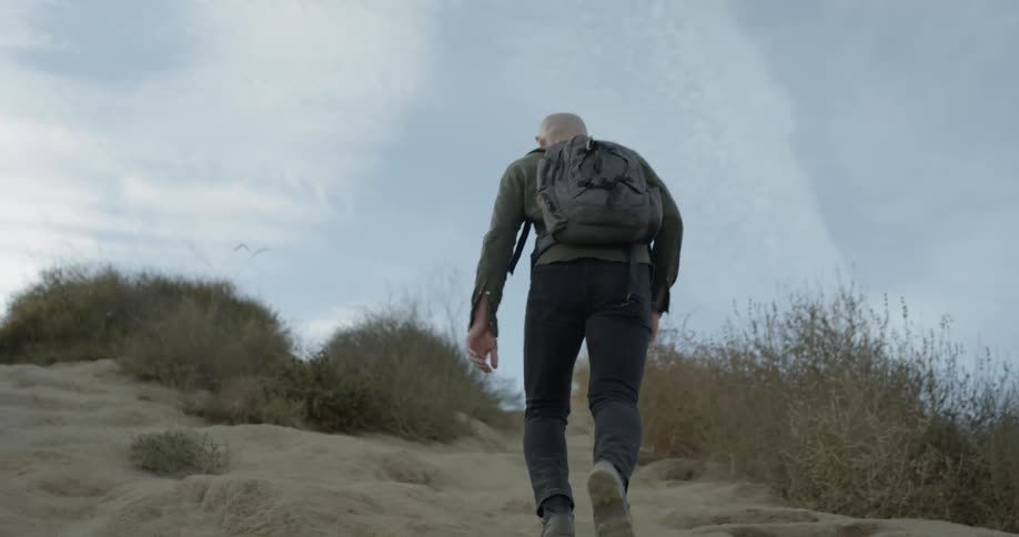A person walking down a sandy path