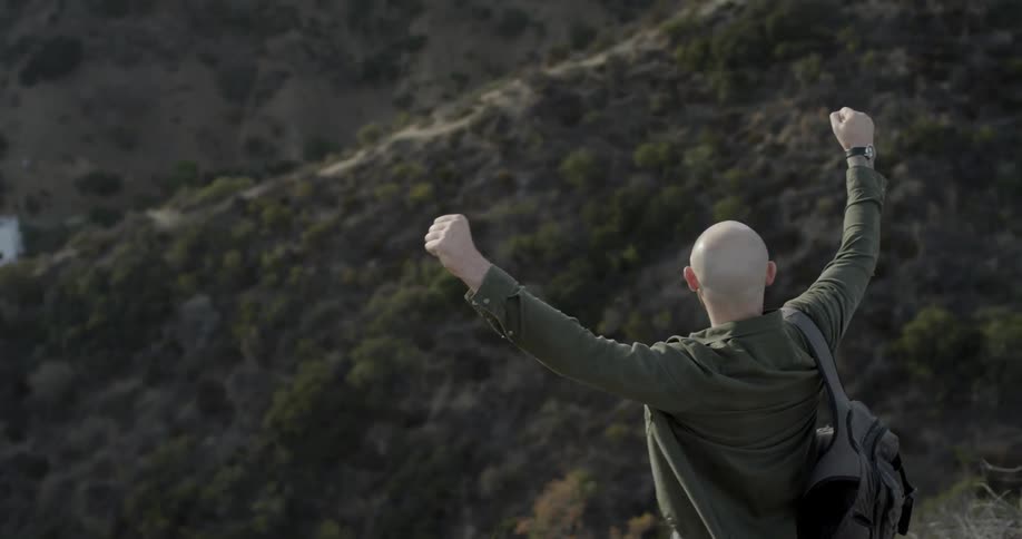 A man is hiking on a hilltop