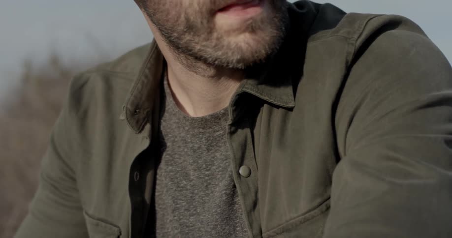 A man sits and looks around