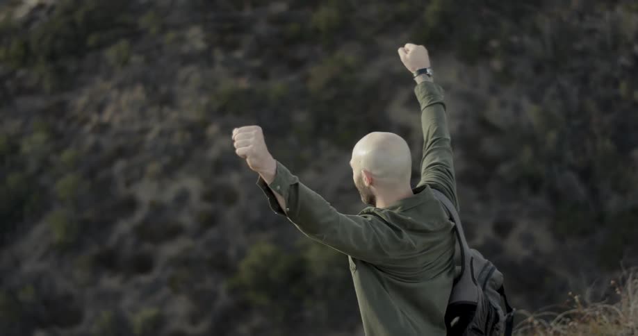 A man walking down a hill and cheering