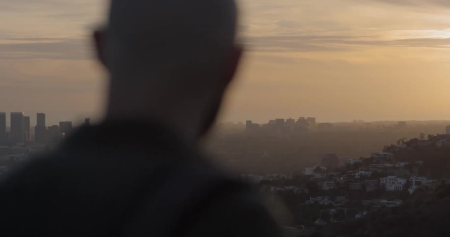 A man looks below to the city