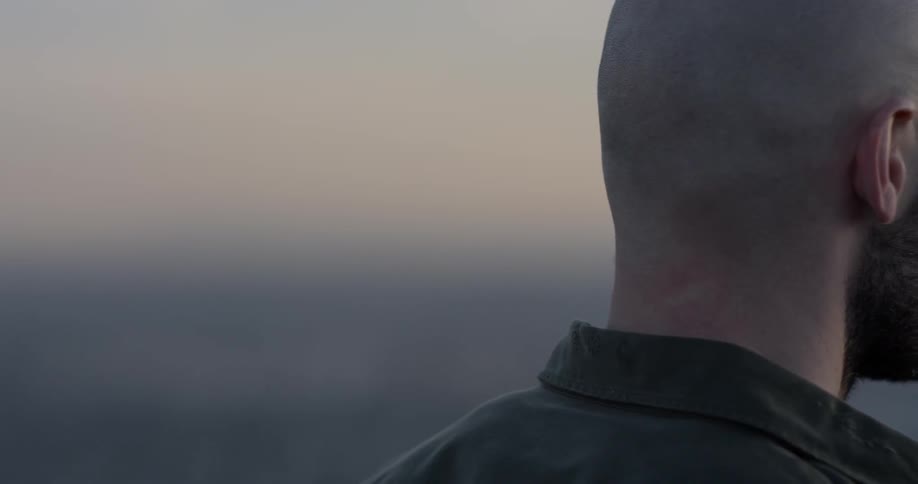 A man stares out over a city skyline