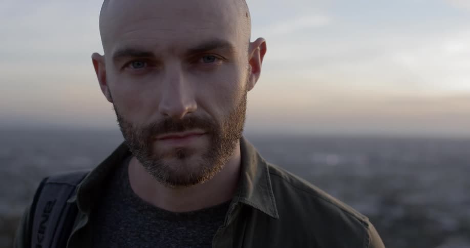 Bearded man outdoors looking at camera