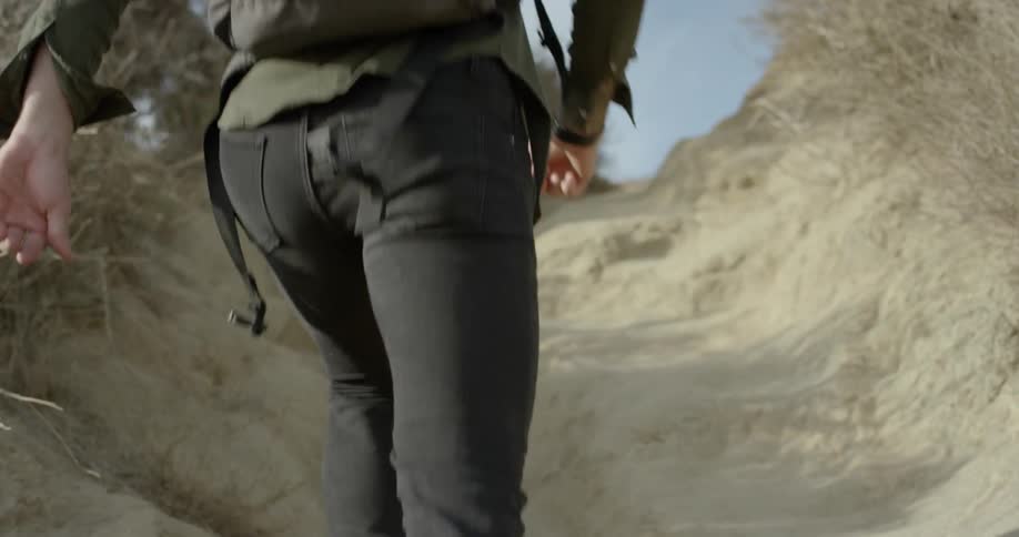 A man jogs up a dirt path on a hill