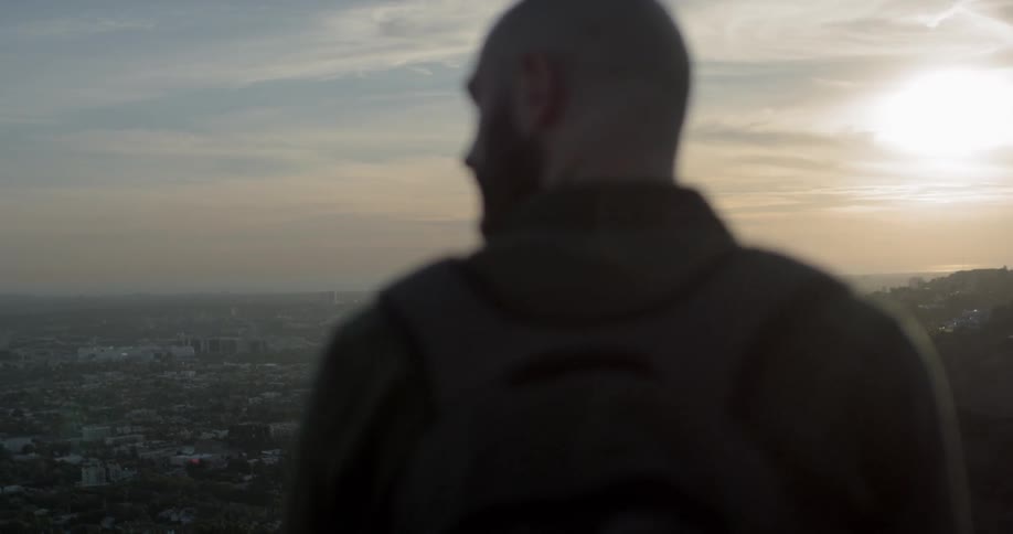 A man viewing a skyline from a hillside