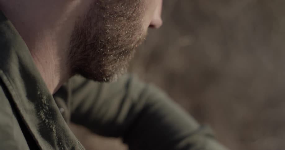 A white man with a beard sits outdoors