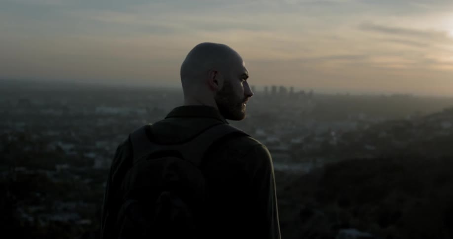 A man walks overlooking a city