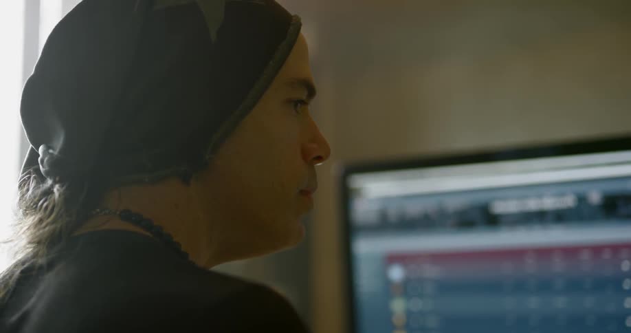 A man looks at computer screens in front of him