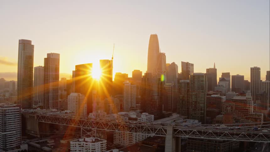 The sun sets behind a city