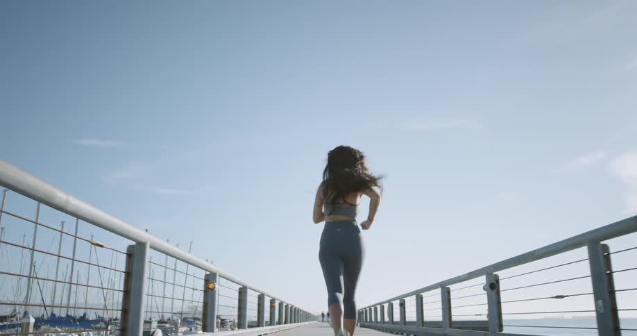 A woman runs along a pier