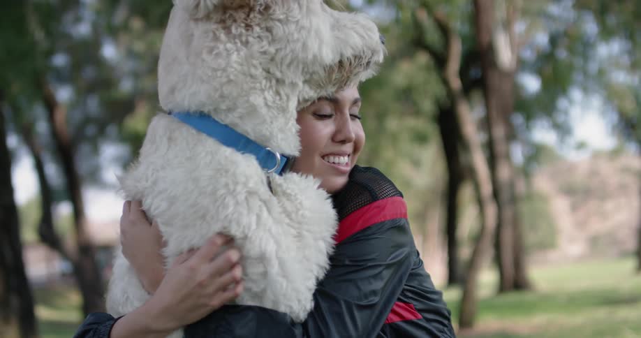 A woman is hugging her dog outdoors