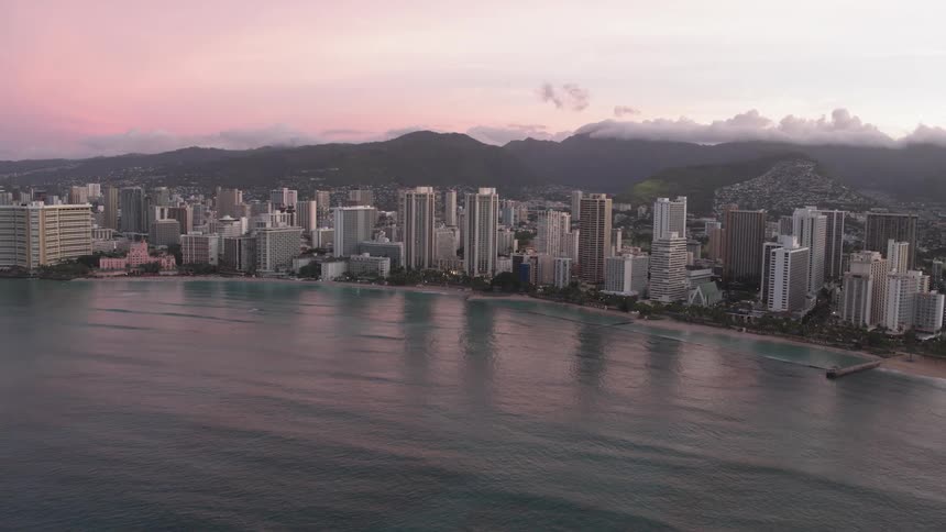 A large urban area sits between mountains and a coast line