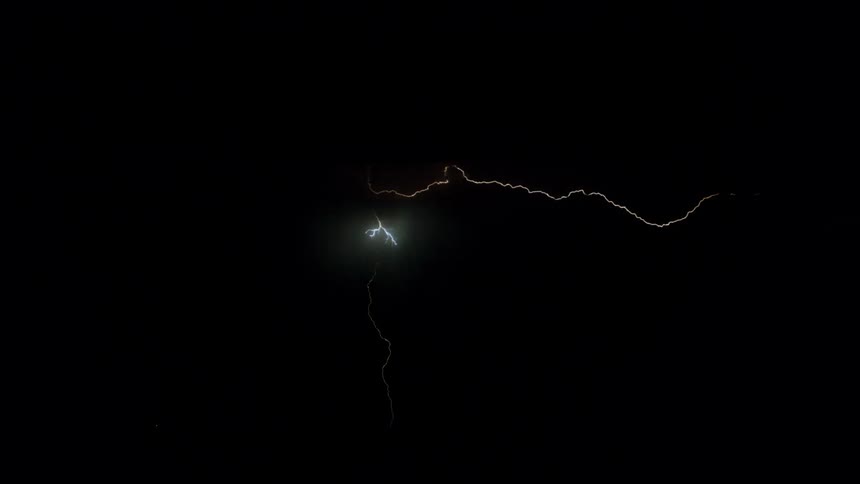 Lightning forming and flashing above a mountain range