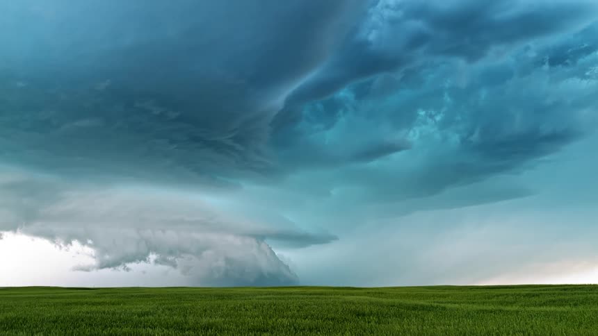 Storm clouds hover over a green plain
