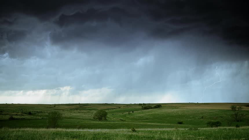Thunder clouds over a wide hilly grassland