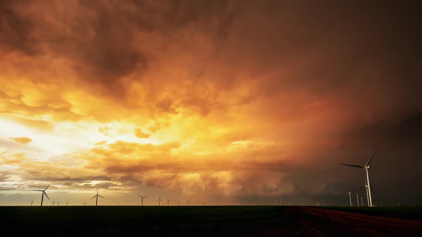 Dark skies loom above a wind turbine farm