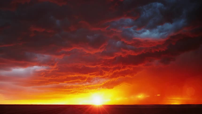 Lightning flashes in storm clouds at sunrise