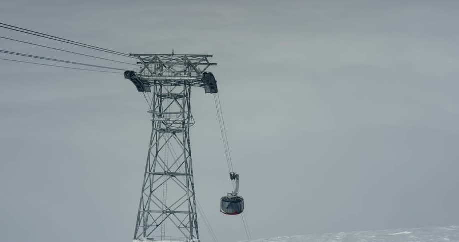 A ski lift goes up the cable to the top of the tower