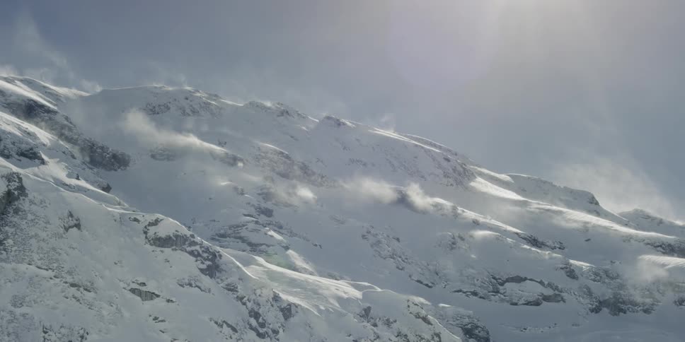 A view from a high up snowy mountainside on a sunny day