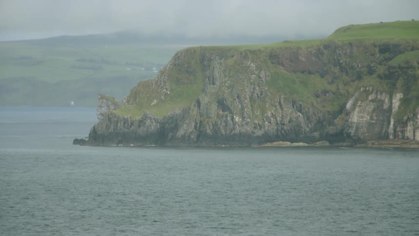 A large moss covered plateau sits in the ocean