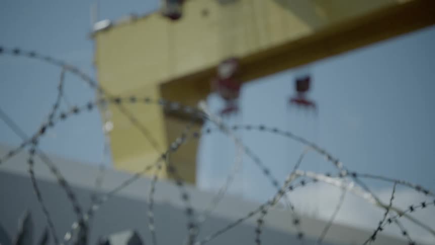 A perimeter fence near a metal structure