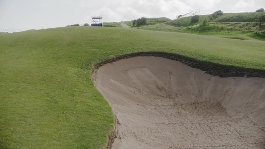 A sand hazard at a well maintained golf course