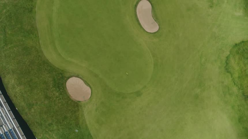 A green golf course with two sand pits