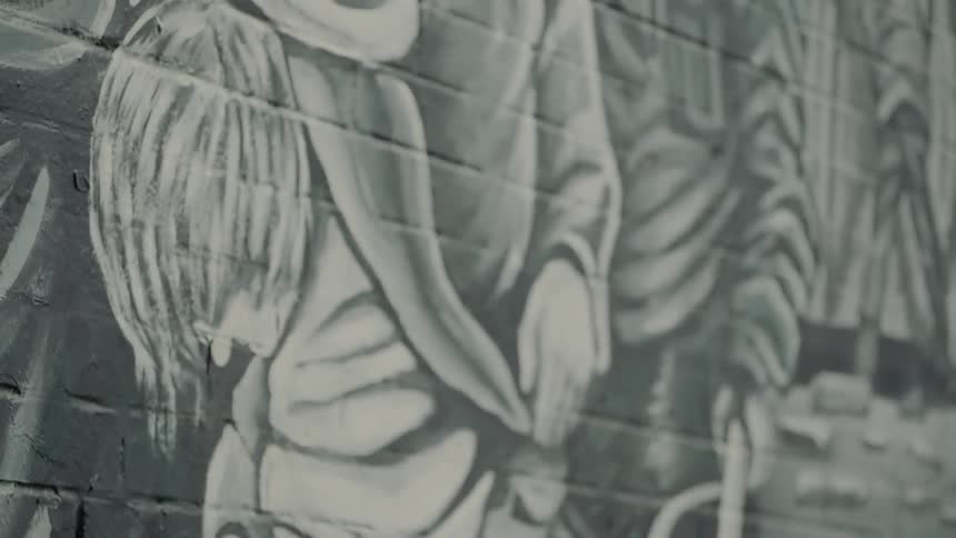Graffiti of person in white on gray brick wall