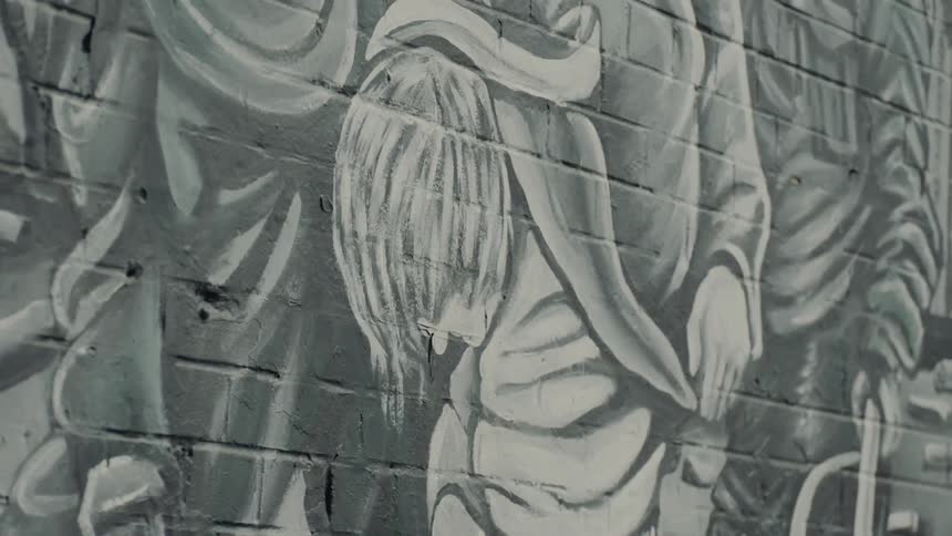 Artistic black and white graffiti on the side of a brick building