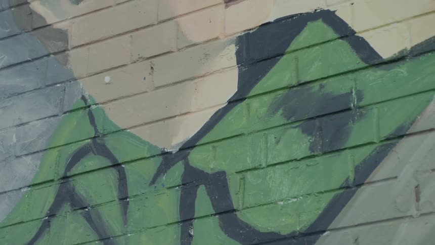 Street art of a man in a uniform on a brick wall