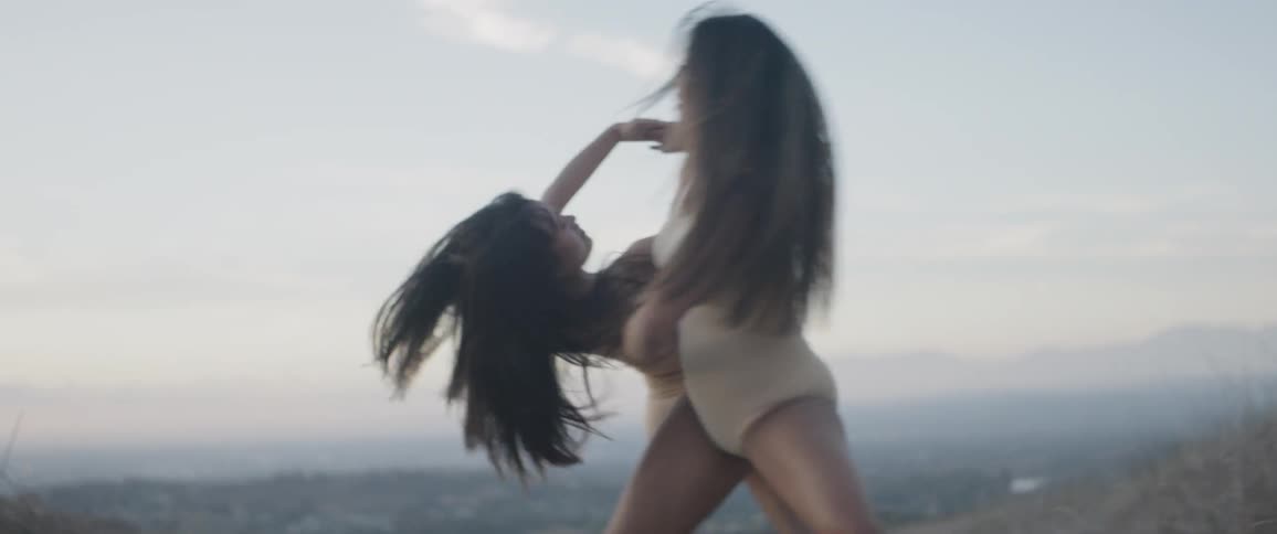 Two young women dance together