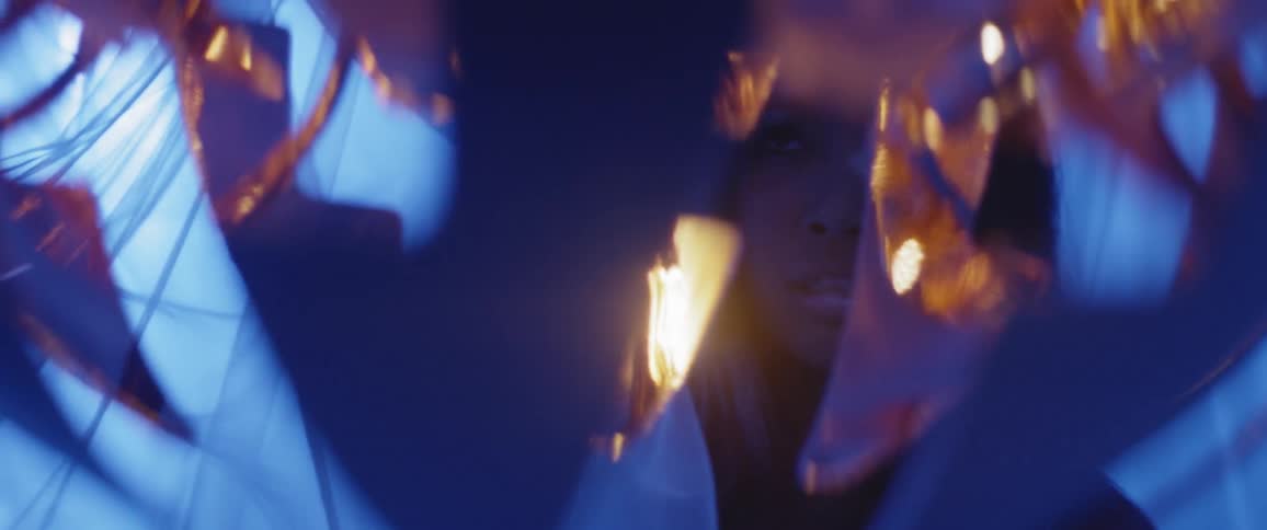 A womans image reflected in fabric with lights
