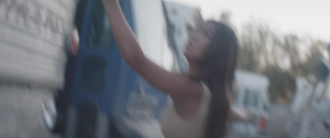 An asian woman dances next to a bus