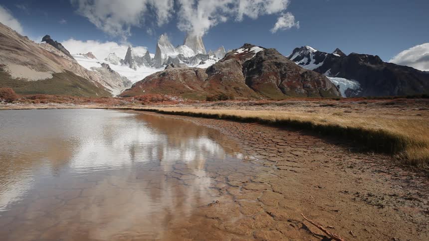 Drying lake in valley near mountain range during the day