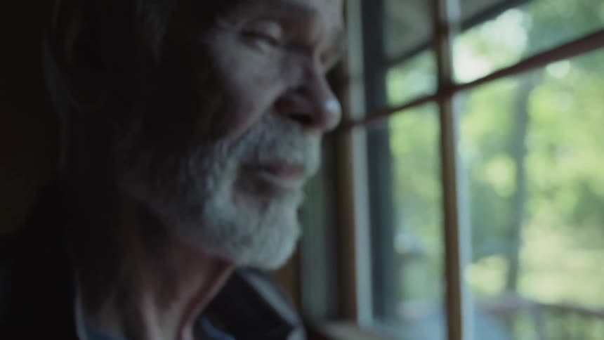 A older man looking at a baseball