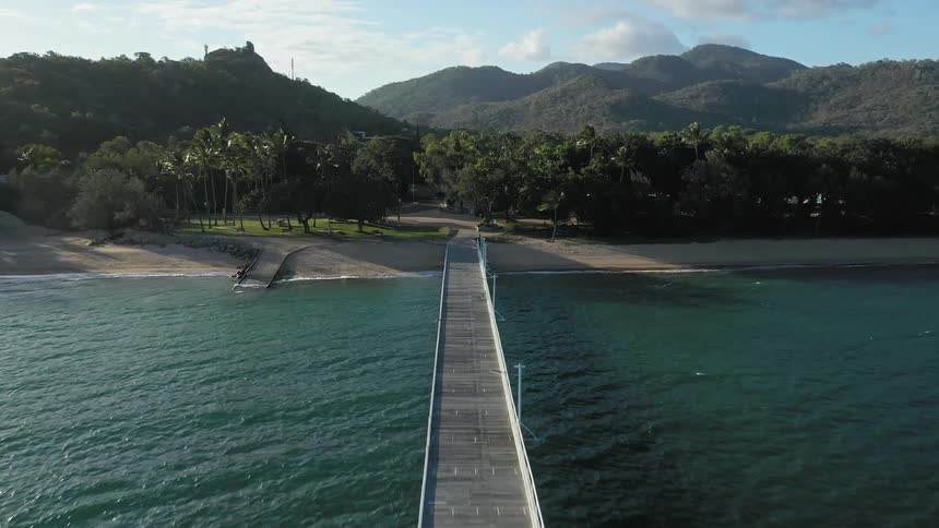 A causeway stretches across water to a beach