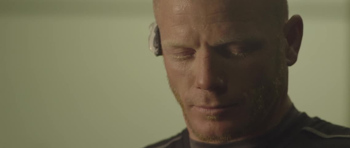 A man with a bluetooth device staring