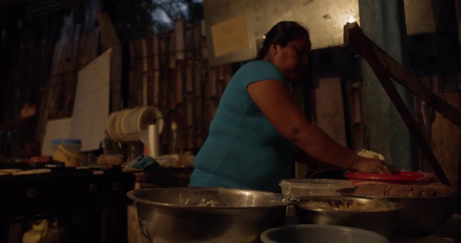 An older hispanic woman prepares food