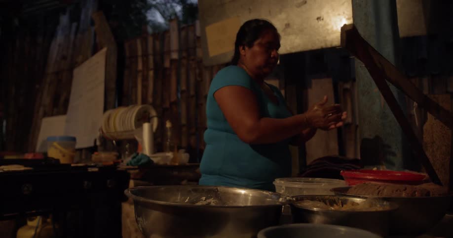 A woman preparing flatbread dough from different containers