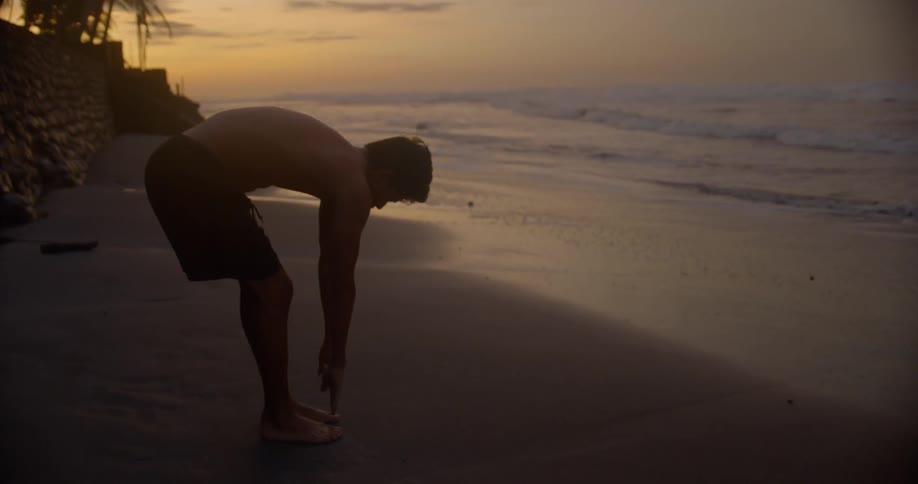 A man stretching on a beach