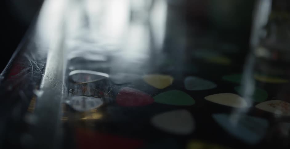 Various color and designs of guitar picks inlayed to a bar top