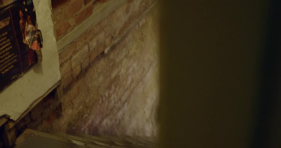 Records are on the wall next to a staircase which runs alongside old exposed brickwork
