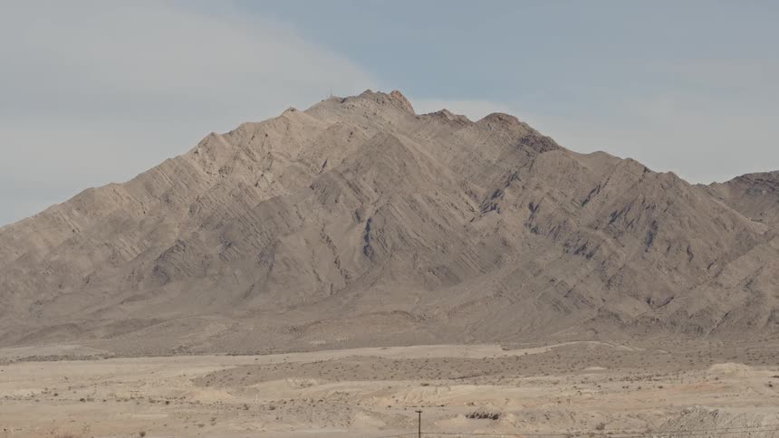 A mountain looms over a desert setting