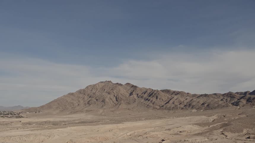 Clouds move over a bleak and desolate desert terrain