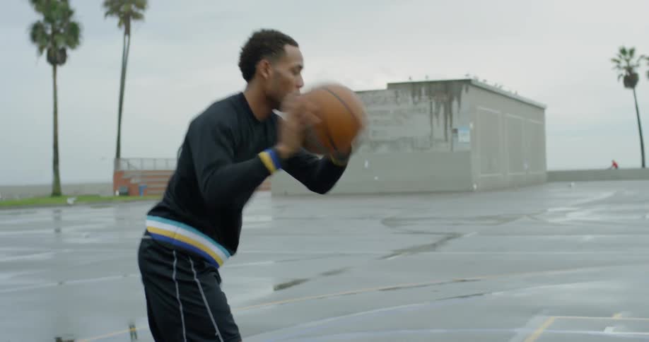 A man does a basketball drill and then shoots it