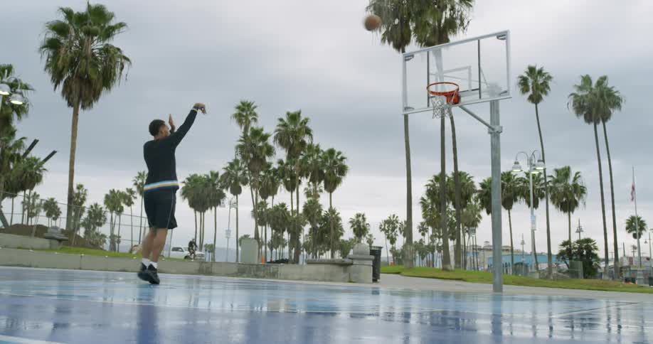 A man shoots a basketball into a hoop