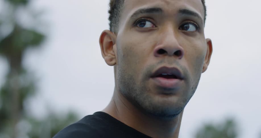 A man is looking around while dribbling a basketball