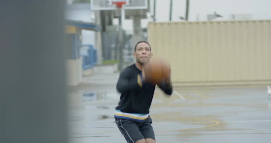 Man dribbles basketball and takes shot while seabird flies by