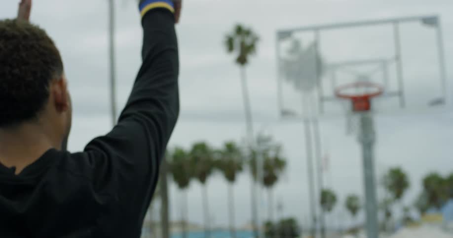 Man shooting basketball hoops outside